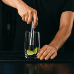 Using cocktail muddler to prepare mojito drink