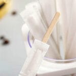 Eco-friendly individually wrapped wooden coffee stirrers for hygienic beverage service.